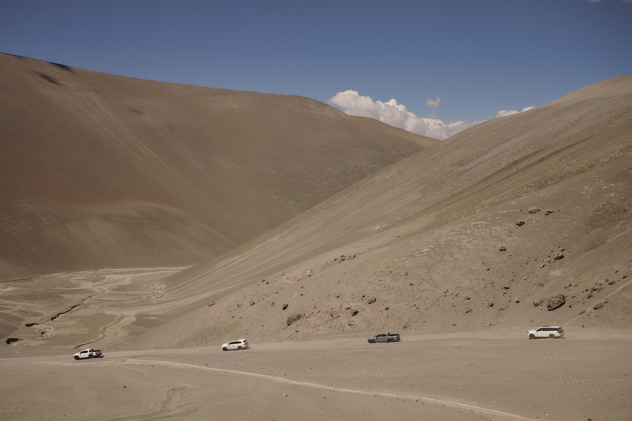 Two Ford Ranger Raptor trucks, a Ford Expedition SUV, and a Ford Everest SUV transport runners and support staff up the world's highest volcano, Ojos del Salado in Chile, ahead of the World's Highest Marathon attempt. U.S. Expedition shown. Argentina Ranger Raptor and Everest shown.